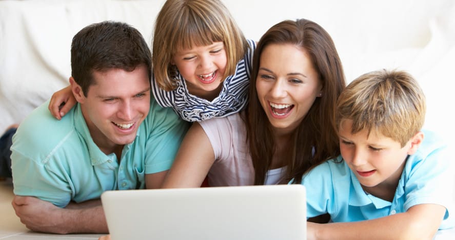 A happy family looking at a laptop - school websites